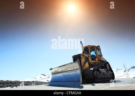 snow cleaning bulldozer on a mountain road in spring Stock Photo