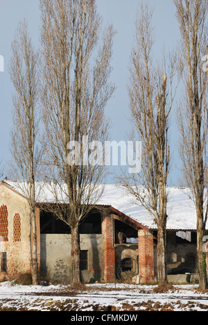 Old country house covered of snow in winter with trees, Po Valley, Italy Stock Photo