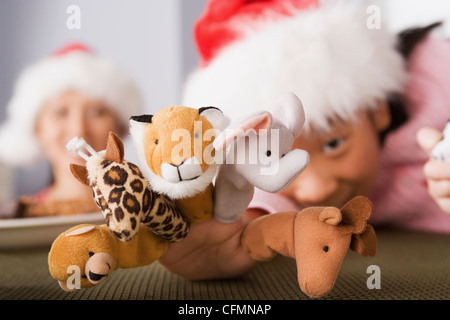 USA, California, Los Angeles, Girl wearing Santa hat playing with finger puppets Stock Photo