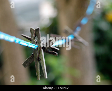 Old pegs on a line in the rain Stock Photo