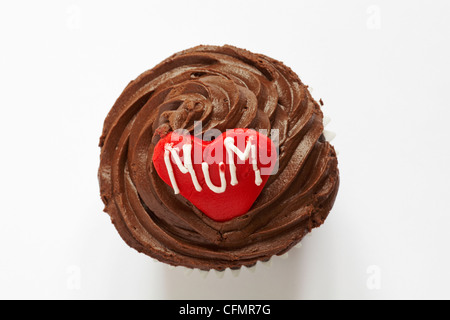 looking down on chocolate cupcake with the word mum iced on red heart for Mothering Sunday, Mothers Day isolated on white background - from above Stock Photo