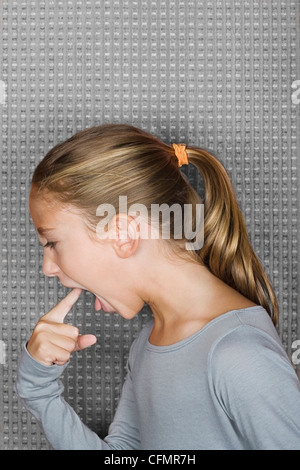Studio portrait of girl (12-13) inserting finger in mouth Stock Photo
