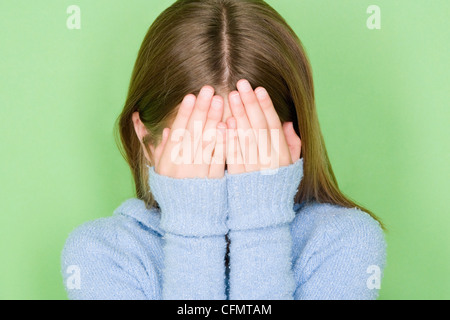 Studio shot portrait of teenage girl covering face, head and shoulders Stock Photo