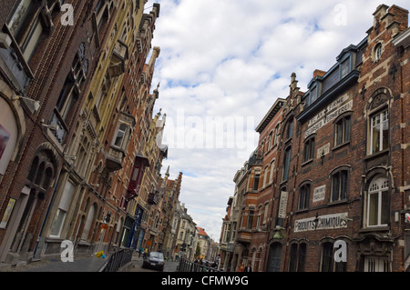 Horizontal view down a traditional narrow road in central Ghent with old terraced gabled buildings on either side. Stock Photo