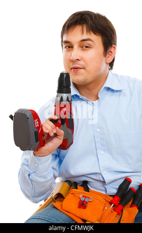 Construction worker blowing smoke off electric screwdriver Stock Photo