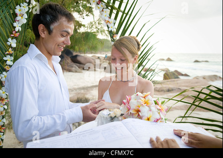 Weddings at the dream beaches on The Seychelles are romantic and common. This German couple enjoys their ceremony on Prasline. Stock Photo