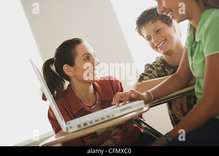 USA, California, Los Angeles, Group of school children with teacher using laptop Stock Photo
