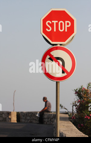 a man sitting behind a road sign. Dubrovnik, Croatia Stock Photo