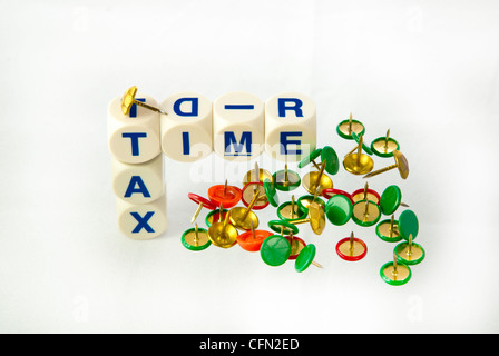 Play on words "Tax Time, with Thumb Tacks Stock Photo