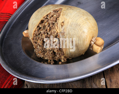 Traditional Scottish Haggis Cooked For A Burns Night Dinner Against A Royal Stuart Tartan Robert Burns Birthday Is January 25, Scotland. Stock Photo