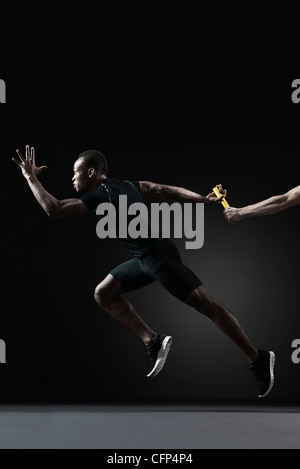 Runners passing baton Stock Photo