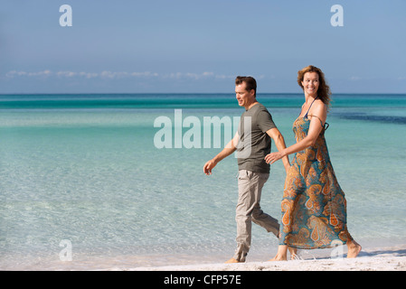 Couple walking leisurely on beach Stock Photo
