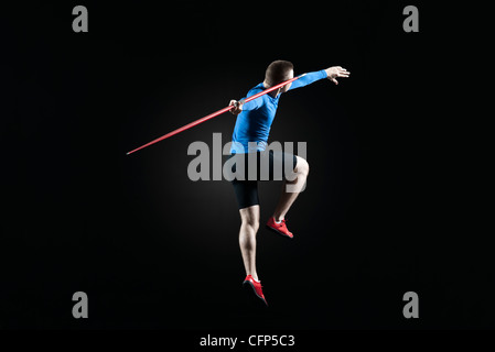 Male athlete leaping with javelin Stock Photo