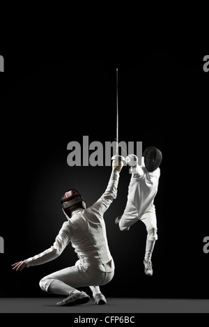 Fencers fencing, one fencer jumping in air Stock Photo
