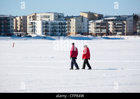 Elderly couple walking on frozen lake, Lappeenranta Finland Stock Photo
