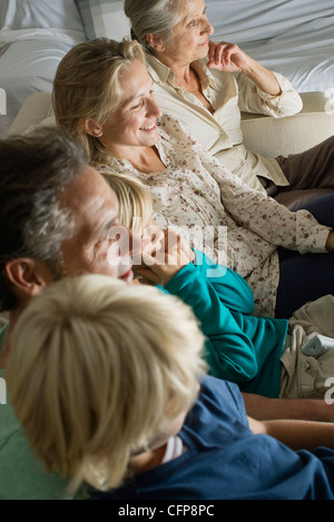 Multi-generation family sitting side by side on sofa, high angle view Stock Photo
