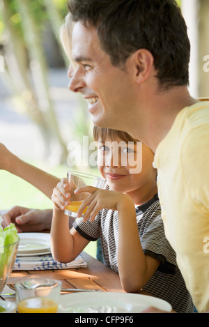 Boy having breakfast with family outdoors Stock Photo