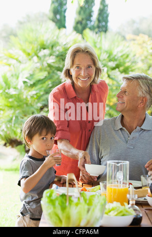 Boy and grandparents having meal outdoors Stock Photo