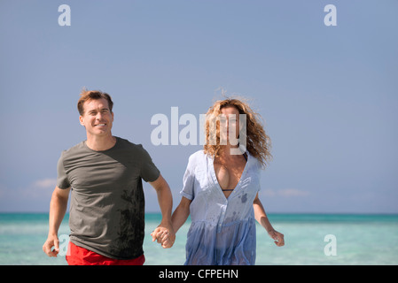 Couple at beach, holding hands Stock Photo