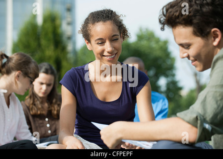 University students studying together outdoors, focus on one woman Stock Photo