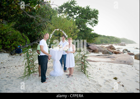 Weddings at the dream beaches on The Seychelles are romantic and common. This German couple enjoys their ceremony on Prasline. Stock Photo