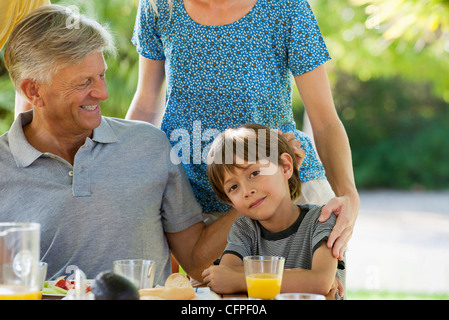Boy and family having meal outdoors, cropped Stock Photo