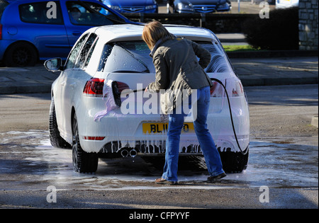 Female motorist using manual car wash. Morrisons Supermarket, Kendal, Cumbria, England, United Kingdom, Europe. Stock Photo