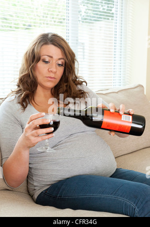 pregnant woman drinking a glass of wine Stock Photo