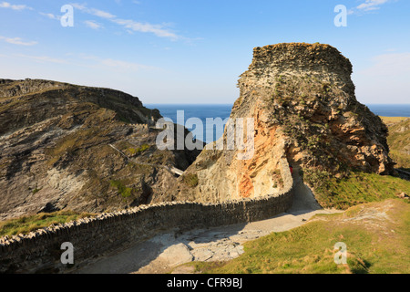 View over stone wall to King Arthur's Camelot Castle on rocky headland from Cornish west coast path. Tintagel Cornwall England UK Stock Photo