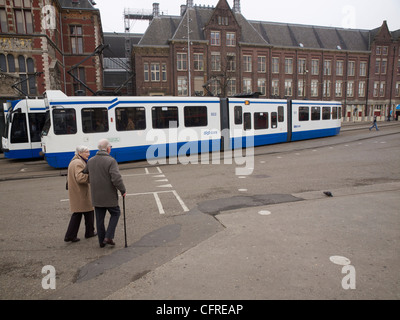 Old couple crossing the street with tram in Amsterdam the Netherlands Stock Photo