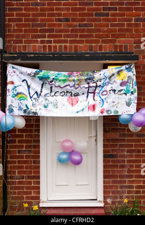 Welcome Home Banner Hanging Over A Front Door Stock Photo