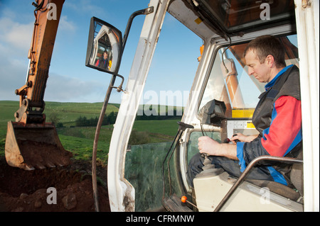 Big excavator digging stone on a hillside. Stock Photo