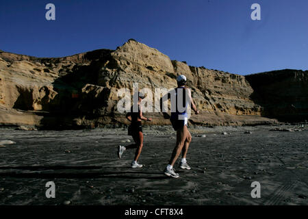 December 17, 2006 San Diego, CA Runners pass a section of the beach, where a sign warns visitors not to use a trail that cuts into a cliff north of Flat Rock, approximately one-half mile south of Torrey Pines State Beach parking lot, in San Diego. The state is planning to build a staircase there. (T Stock Photo