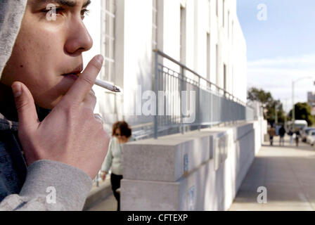 An unidentified person smokes a cigarrtte as he waits outside the Alameda County Superior Courthouse in Oakland, Calif., on  Wednesday, Jan. 10, 2007.  (Ray Chavez/The Oakland Tribune) Stock Photo