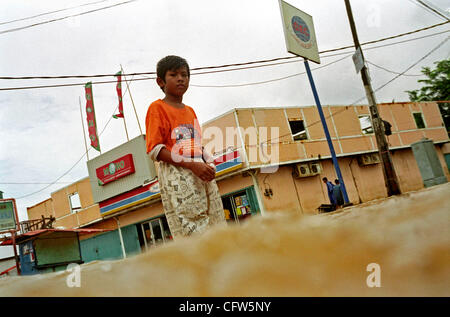 BEKASI, WEST JAVA, INDONESIA FEBRUARY 4, 2007:  An Indonesian boy wades in front of the flooded shop. Severe storm caused the flooding in Indonesia capital, as river broke their banks, inundating thousands of homes and business.  Photo by Edy Purnomo/JiwaFoto Stock Photo