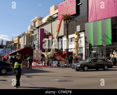 Feb 23, 2007 - Hollywood, CA, USA - A traffic officer directs car while work crews using a crane, place an oversized Oscar statue on the red carpet at the corner of Hollywood Boulevard and Highland near the Kodak Theater, Friday, February 23, 2007. The 79th Academy Awards are set for Sunday February Stock Photo