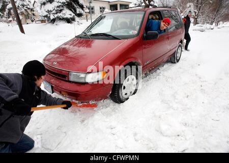 RENEE JONES SCHNEIDER • reneejones@startribune.com.Minneapolis, MN - March 3, 2007 - Matt Johnson, Gina Jorgenson and her husband Karl Jorgenson (not pictured) helped Ramon Urgiles get his mini-van unstuck from the middle of the road on the corner of 26th Avenue and Buchanan Street Friday morning.   Stock Photo