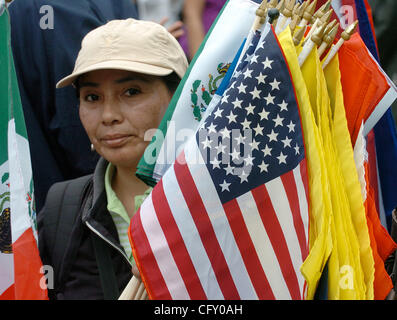 An unidentified woman sells flags from around the world as hundreds of immigrant community members rally in Washington Square Park and march up Broadway to highlight the humanitarian crisis created by immigration raids, deportations, and the failure of the federal government to enact immigration ref Stock Photo