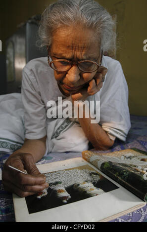 Sumitra Mukherjee, 80, looks through an art magazine as she relaxes on her bed (number 12) at an Old Age Home in New Delhi, India on Tuesday May 15, 2007, celebrated as the International Family Day.  Photographer: Pankaj Nangia Stock Photo