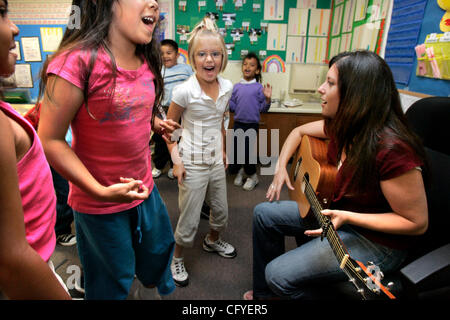 May 16, 2007, Oceanside, California At San Luis Rey Elementary School teacher CHERYL SULITEANU plays on her guitar '?Que Tiene Rojo?' (Who has (is wearing) Red?), an audience participation song, to her first graders who are dancing to the music. I.D.'s, LtoR: NICOLE KOUFOU (far left partially obscur Stock Photo