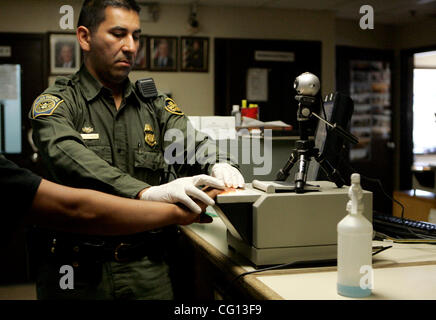 July 23, 2007 Jamul, CA Senior Border Patrol Agent MANNY ESPARZA uses an electronic fingerprinting device and camera at the Jamul Border Patrol checkpoint to process a person found crossing into the United States from Mexico in the Tecate area. Laura Embry/San Diego Union-Tribune/Zuma Press, copyrig Stock Photo