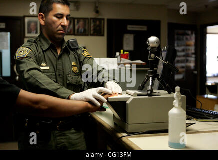 July 23, 2007 Jamul, CA Senior Border Patrol Agent MANNY ESPARZA uses an electronic fingerprinting device and camera at the Jamul Border Patrol checkpoint to process a person found crossing into the United States from Mexico in the Tecate area. Laura Embry/San Diego Union-Tribune/Zuma Press, copyrig Stock Photo