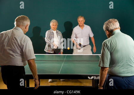 Senior men and women ranging in age from their 70's to their 90's play ping pong at a seniors' athletic facility in the retirement community of Laguna Woods, CA. MODEL RELEASE Stock Photo