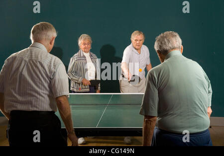 Senior men and women ranging in age from their 70's to their 90's play ping pong at a seniors' athletic facility in the retirement community of Laguna Woods, CA. MODEL RELEASE Stock Photo