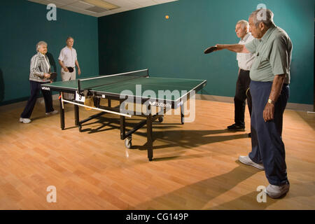 Senior men and women ranging in age from their 70's to their 90's play ping pong at a seniors' athletic facility in the retirement community of Laguna Woods, CA. MODEL RELEASE Stock Photo