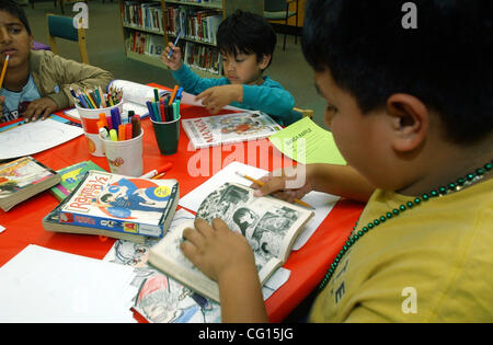 Miguel Contreras, 10, right, flips through a manga comic book at the San Pablo Library, Wednesday, July 25, 2007, where drawing supplies were provided for an afternoon of manga drawings, Japanese comics and anime, for youth of all ages in San Pablo, Calif. Miguel's brother, Joshua Contreras, 4, cent Stock Photo