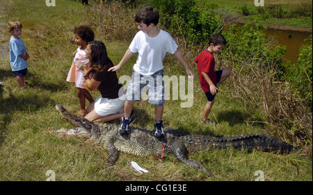 Aug 09, 2007 - Bossier City, LA, USA - Local residents have their photo made around this 9' 8' alligator that was killed after being caught in the Flat River Thursday afternoon in Bossier City. CADE MCCLANAHAN is 'surfing' on the gator. (Credit Image: © Jim Hudelson/Shreveport Times/ZUMA Press) REST Stock Photo