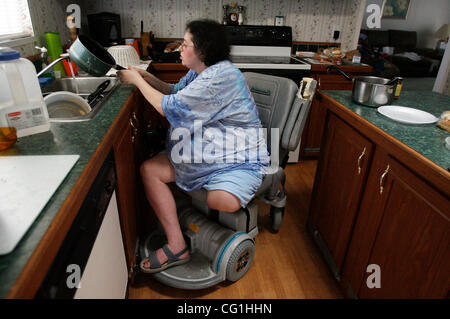 Aug 16, 2007 - Atlantis, FL, USA - ELISSA WEHNER cleans up around the house on August 16, 2007.  Although her family has to help put away dishes in the high cabinets, Elissa still washes the dishes, loads the dishwasher, and puts away pots and pans in the lower cabinets.  Elissa Wehner goes to rehab Stock Photo