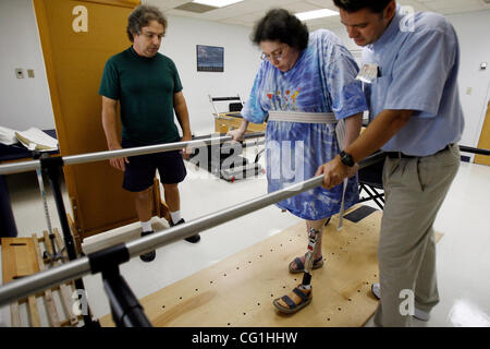 Aug 16, 2007 - Atlantis, FL, USA - Elissa Wehner walks on the parallel bars with the help of her physical therapist, Kenneth O' Sullivan, while her husband, Tom Wehner looks on.  Elissa Wehner goes to rehabilitative therapy at JFK hospital's outpatient facility on August 16, 2007 (Credit Image: © J. Stock Photo