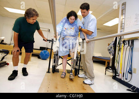 Aug 16, 2007 - Atlantis, FL, USA - Elissa Wehner walks on the parallel bars with the help of her physical therapist, Kenneth O' Sullivan, while her husband, Tom Wehner looks on.  Elissa Wehner goes to rehabilitative therapy at JFK hospital's outpatient facility on August 16, 2007. (Credit Image: © J Stock Photo